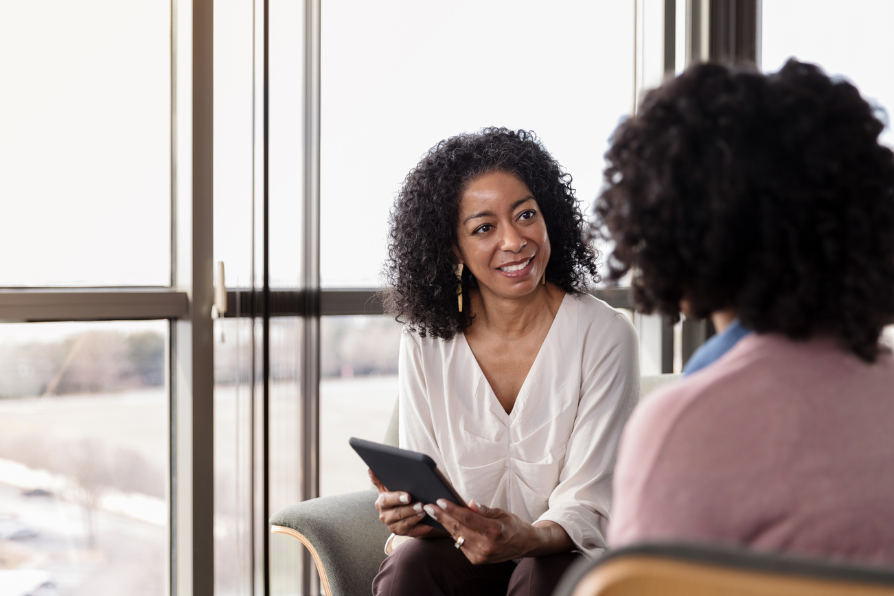 Female counselor listens to female patient during counseling session